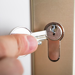 Close-up Of Person's Hand Holding Broken Key Inserting In Keyhole